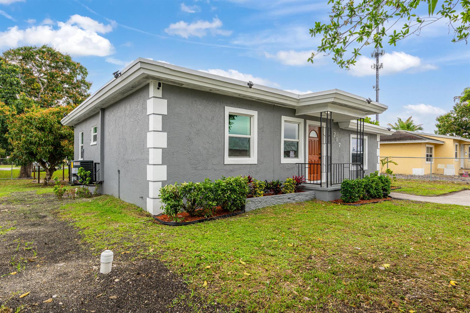 A gray single-story house with white corner accents and a small front porch — 217 NW 14th Street, Belle Glade FL 33430, BELLE GLADE, FL