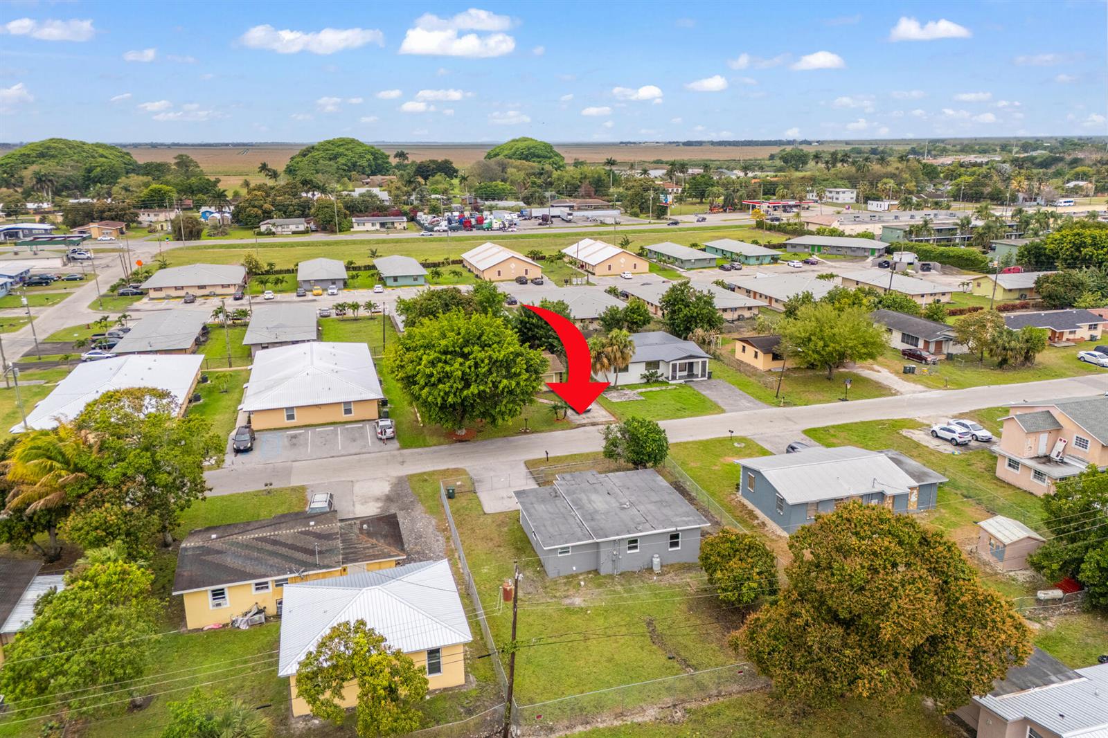 An aerial view shows a residential neighborhood with a red arrow pointing to a house — 217 NW 14th Street, Belle Glade FL 33430, BELLE GLADE, FL