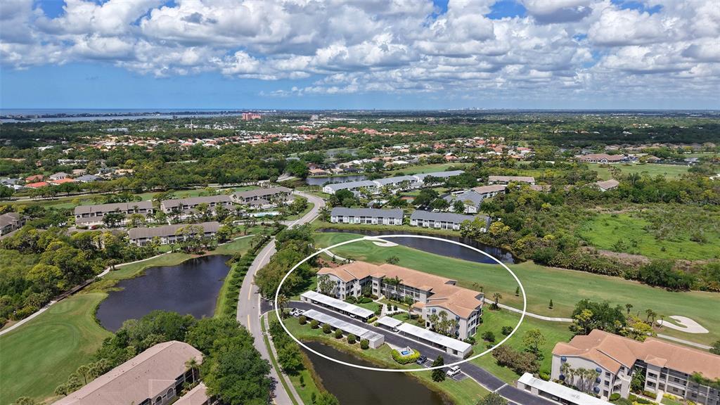 An aerial view shows a multi-story apartment building surrounded by a golf course and ponds — 9630 CLUB SOUTH CIRCLE UNIT 6202, SARASOTA, FL