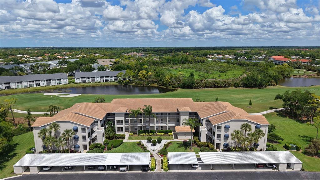 An aerial view shows a multi-story apartment building with covered parking and a golf course — 9630 CLUB SOUTH CIRCLE UNIT 6202, SARASOTA, FL