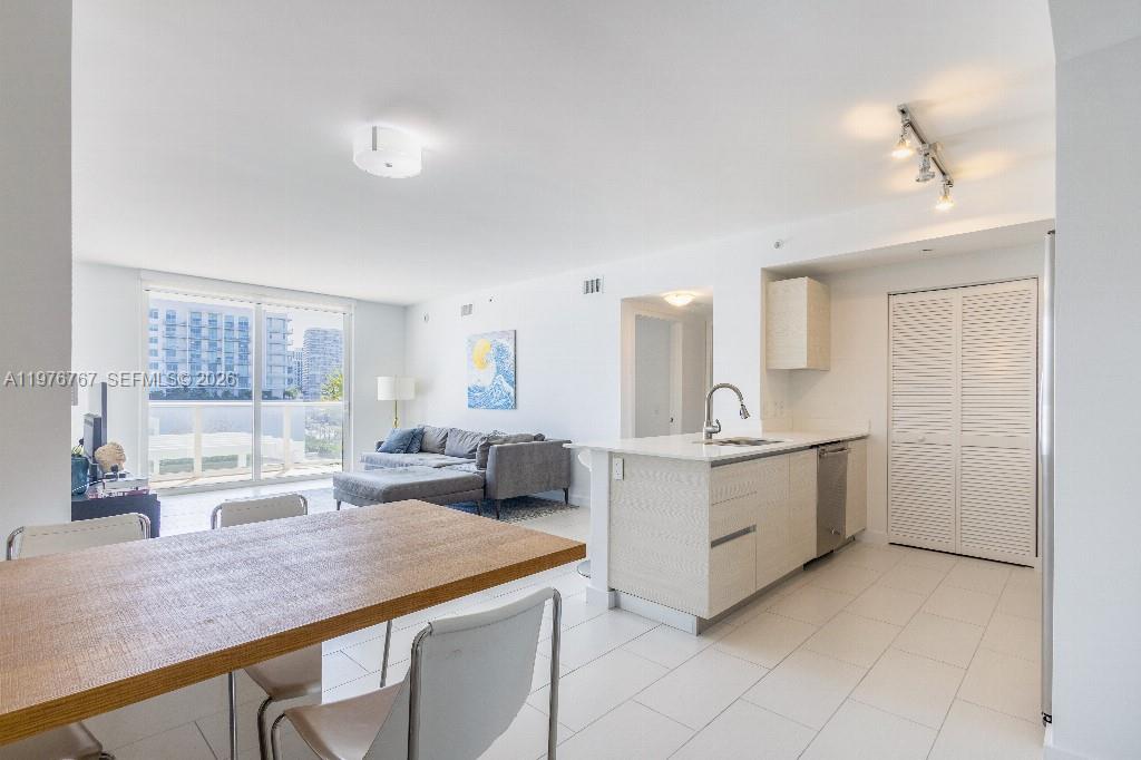 This open-concept living area features a kitchen with light cabinetry and a dining space — 4250 Biscayne Blvd # 816, Miami FL 33137, MIAMI, FL