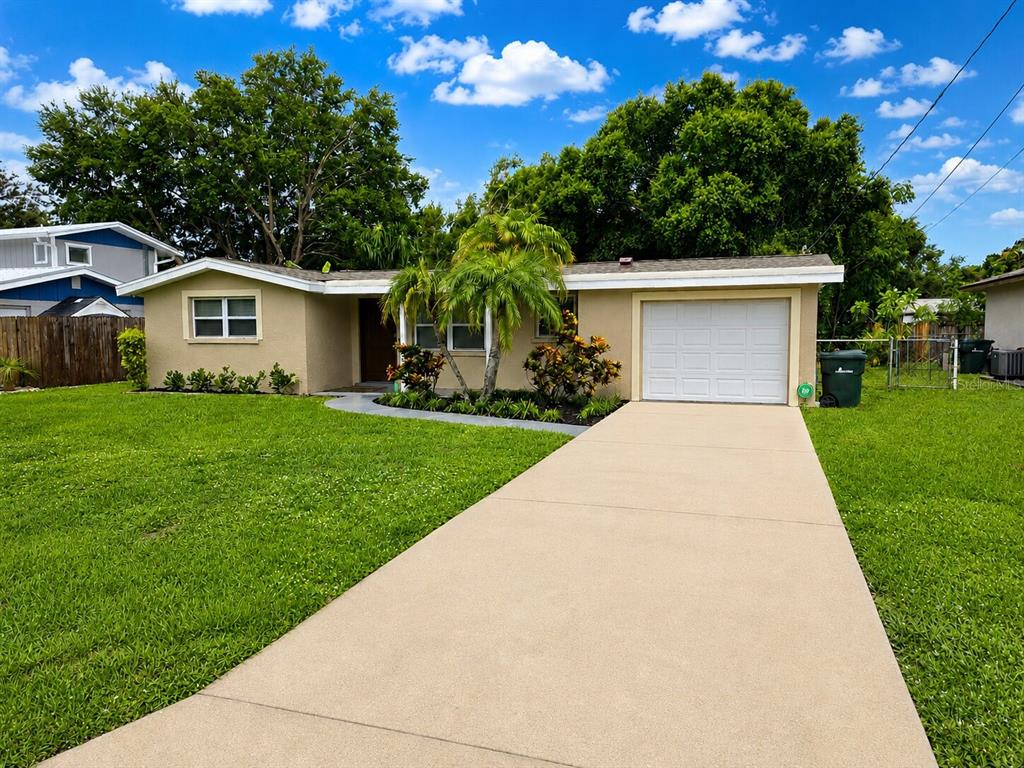 A single-story house with a beige exterior, a concrete driveway, and a one-car garage — 4200 WINTHROP STREET, SARASOTA, FL