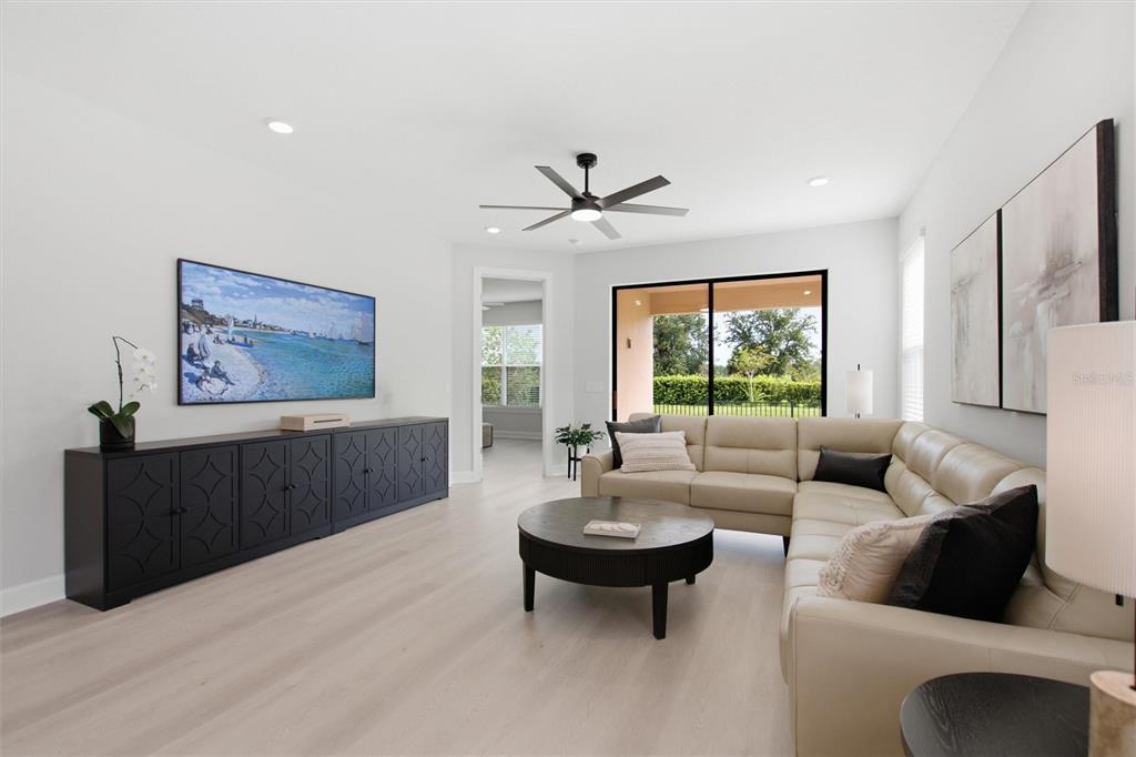 A living room features a beige sectional sofa, a black media console, and a ceiling fan — 1369 LOMBARDI COURT, POINCIANA, FL