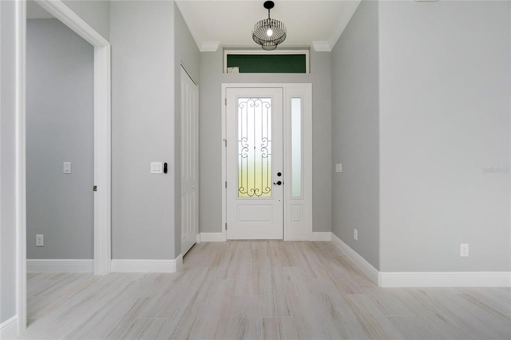 An entryway features light gray walls, wood-look tile flooring, and a white front door — 13344 GERSHWIN LANE, PORT CHARLOTTE, FL