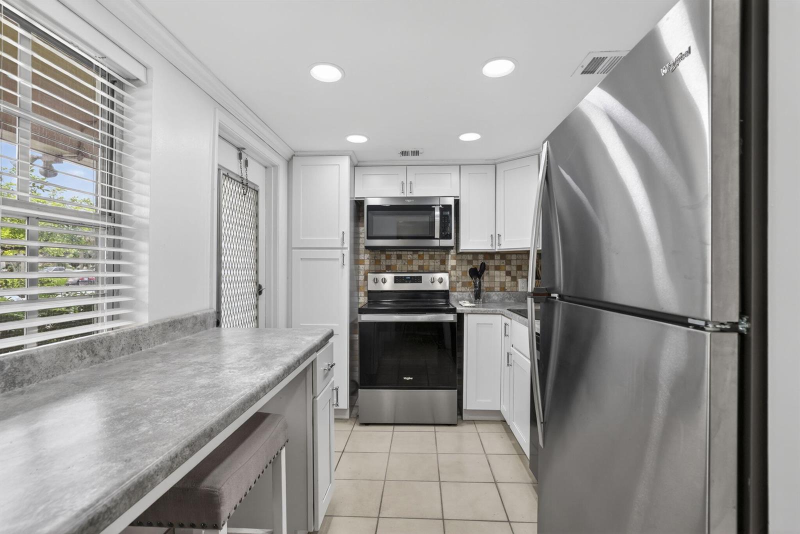 A kitchen with white cabinets, stainless steel appliances, a gray countertop, and tile flooring — 3150 N Palm Aire Drive # 108, Pompano Beach FL 33069, POMPANO BEACH, FL