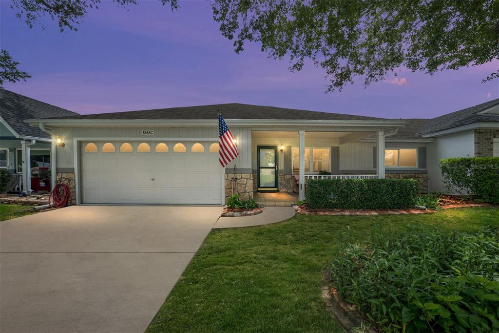 A single-story house with a two-car garage, a concrete driveway, and a large shade tree — 8555 SW 93RD STREET UNIT C, OCALA, FL