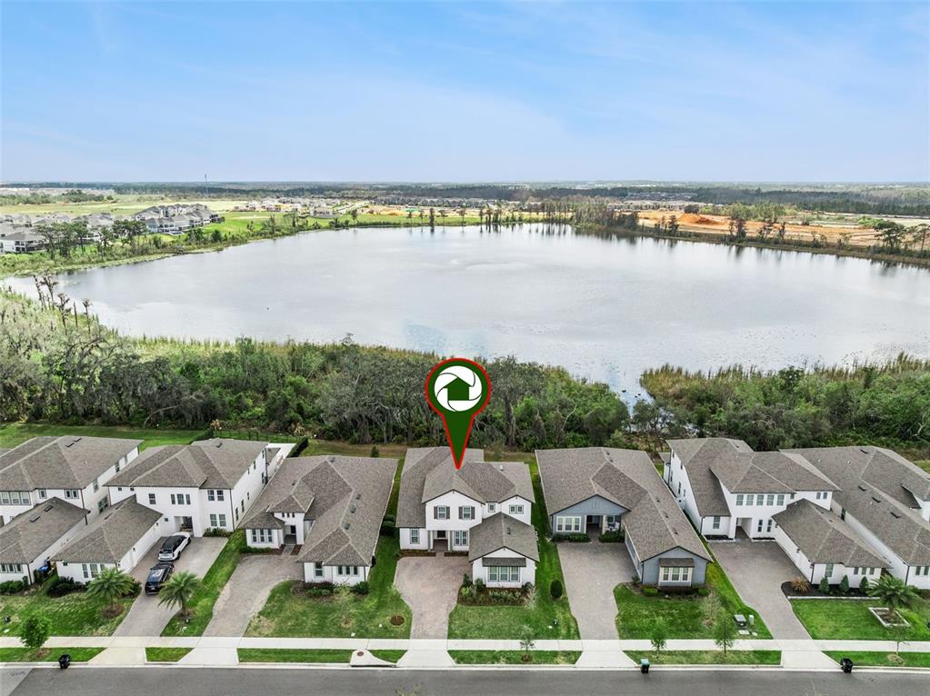 An aerial view shows a row of suburban houses situated along the edge of a lake — 17588 LAKE STAR ROAD, WINTER GARDEN, FL