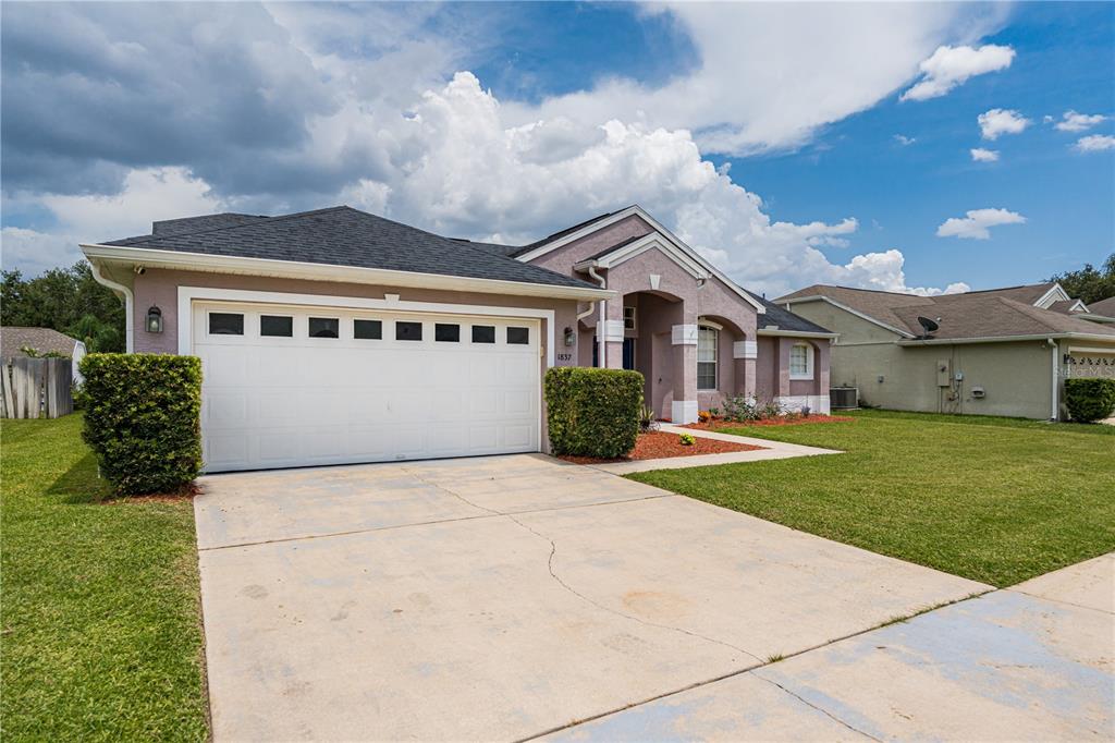 A single-story house with a two-car garage, a concrete driveway, and a manicured lawn — 1837 FLORENCE VISTA BOULEVARD, ORLANDO, FL