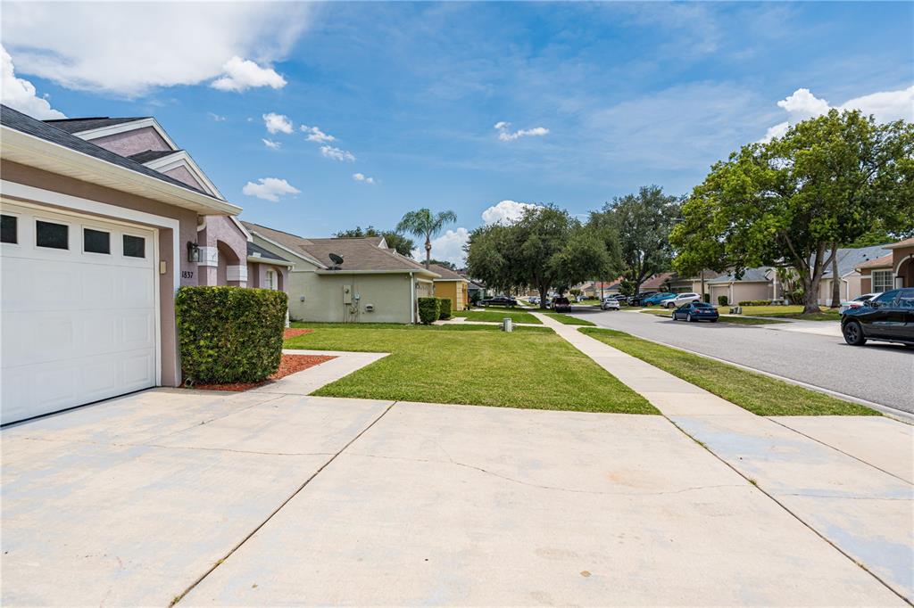 A suburban street view showing a house exterior, driveway, lawn, and parked cars — 1837 FLORENCE VISTA BOULEVARD, ORLANDO, FL