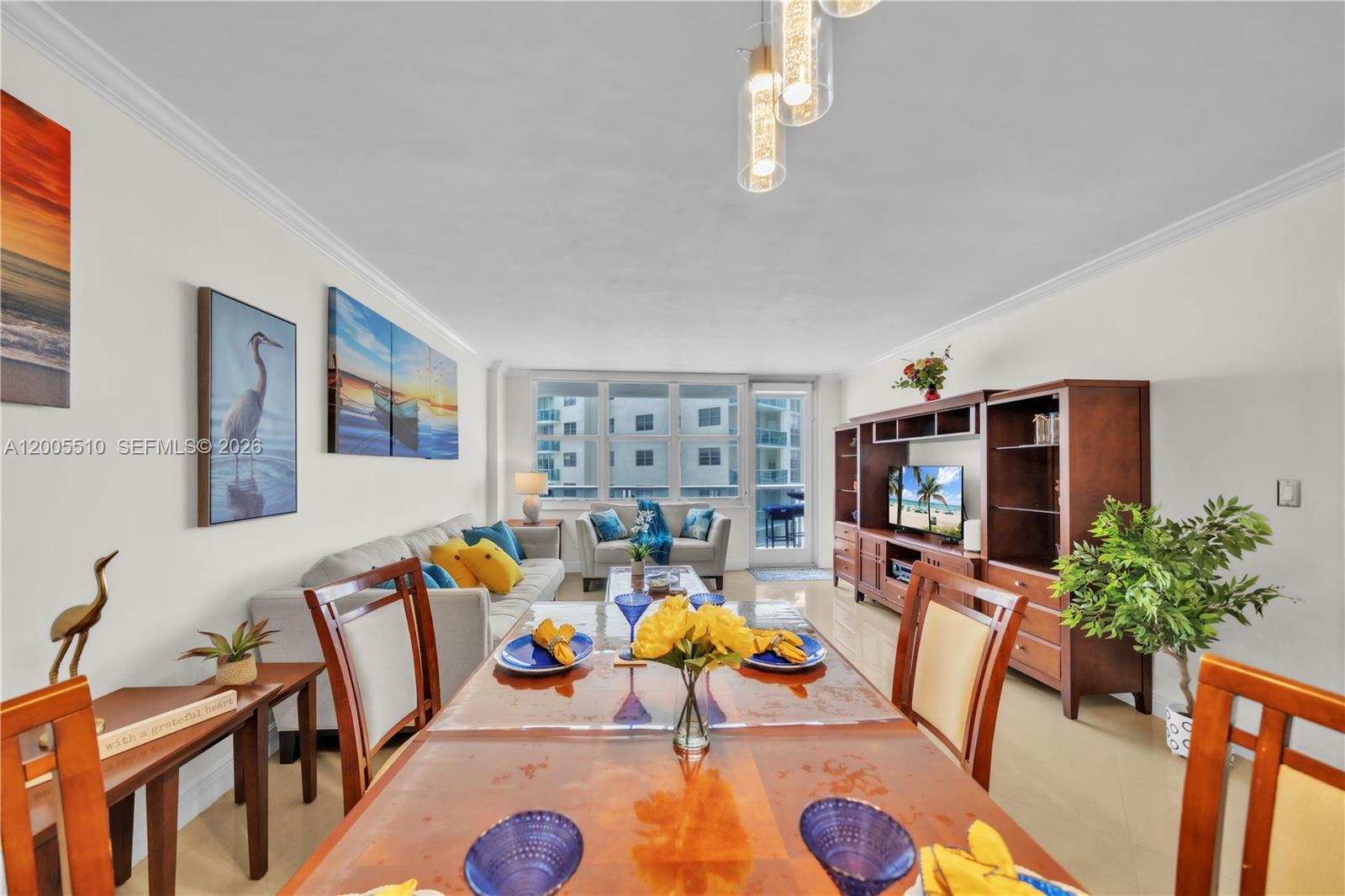 A dining area and living room with light tile floors, wooden furniture, and coastal decor — 3725 S Ocean Dr # 1220, Hollywood FL 33019, HOLLYWOOD, FL