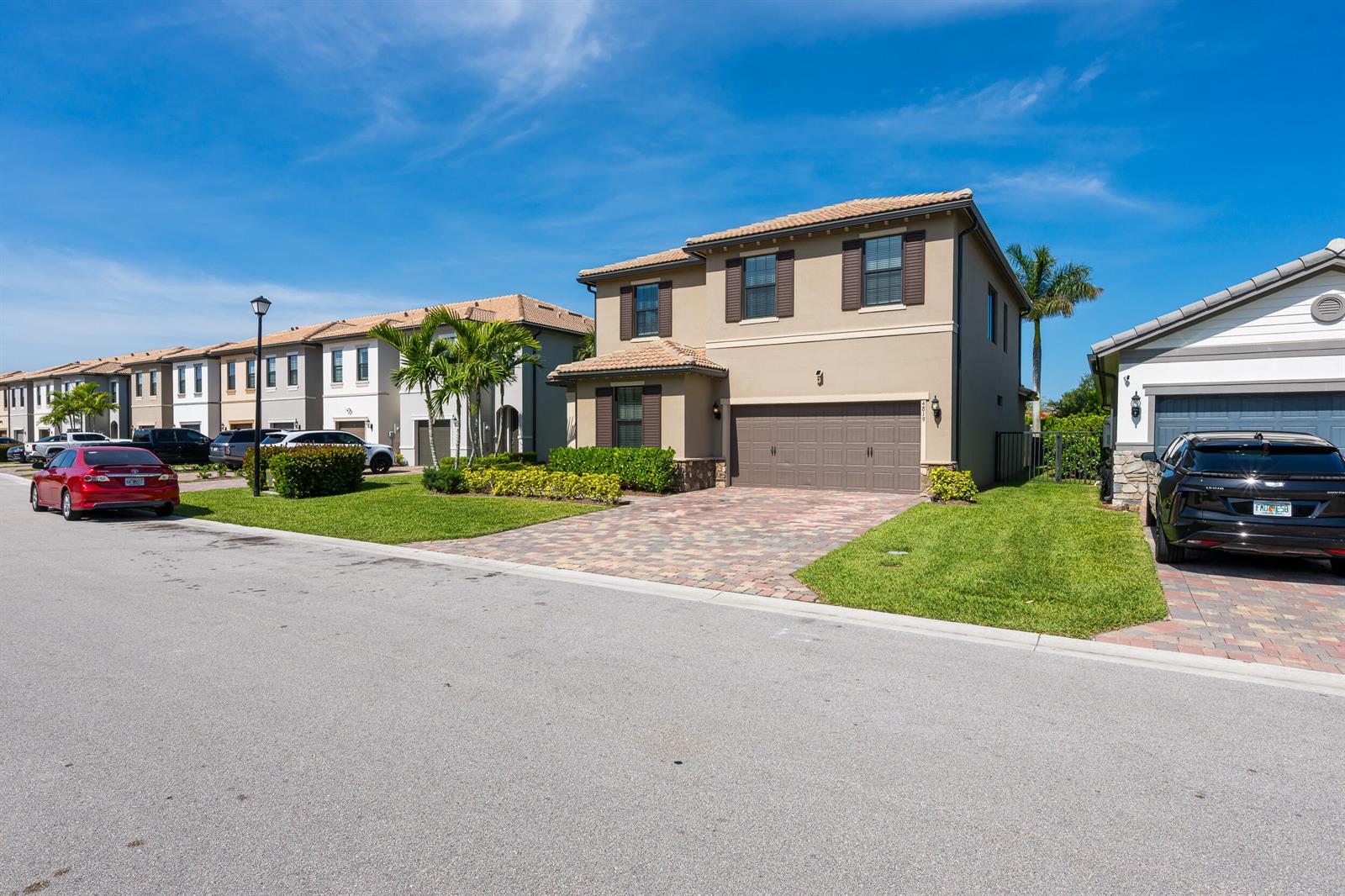 A two-story tan house with a brown garage and a paved driveway sits on a street — 4819 Chantilly Road, Lake Worth FL 33467, LAKE WORTH, FL