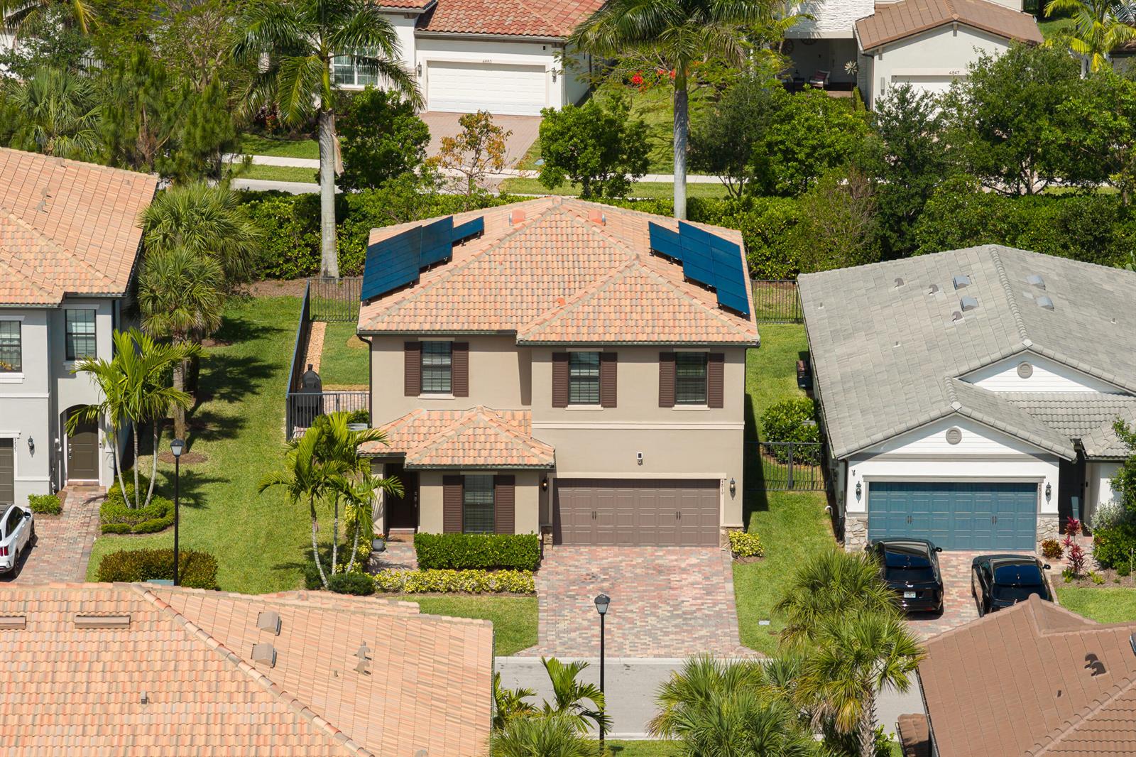 An aerial view of a two-story suburban house with solar panels on the roof — 4819 Chantilly Road, Lake Worth FL 33467, LAKE WORTH, FL