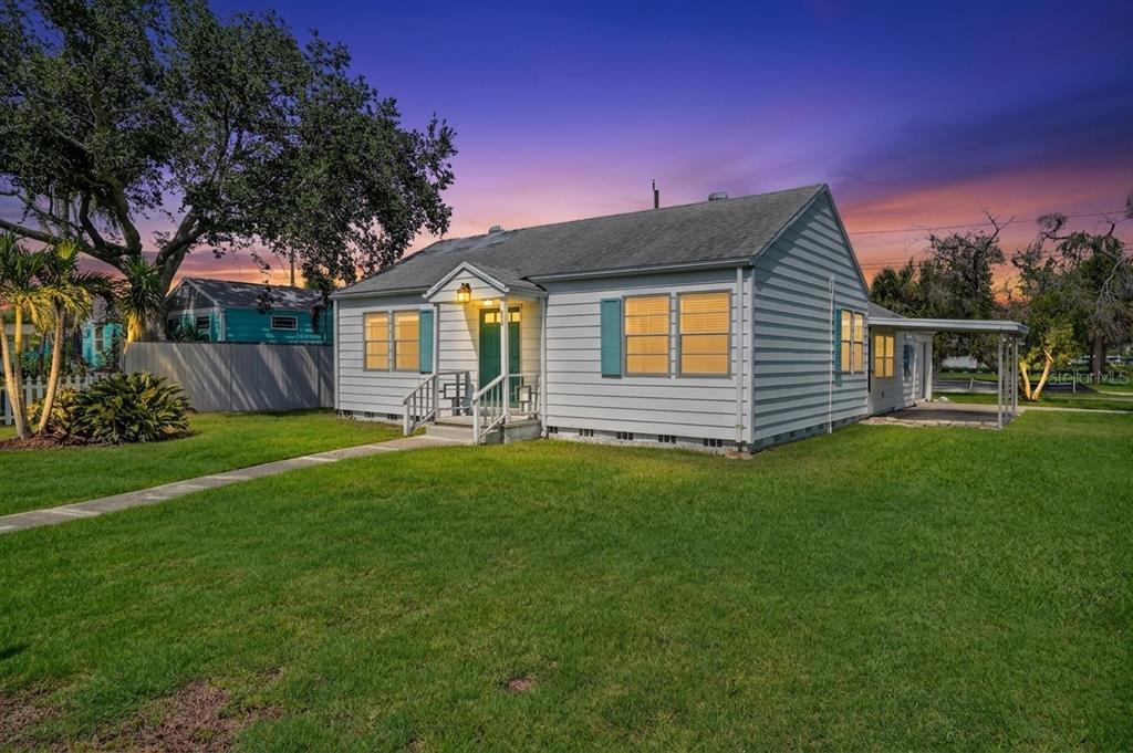 A single-story house with light gray siding, a green front door, and a grassy lawn — 3050 DUPONT STREET S, GULFPORT, FL