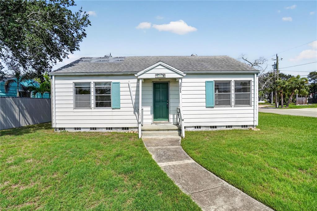 A single-story house with white siding, a green front door, and a concrete walkway — 3050 DUPONT STREET S, GULFPORT, FL