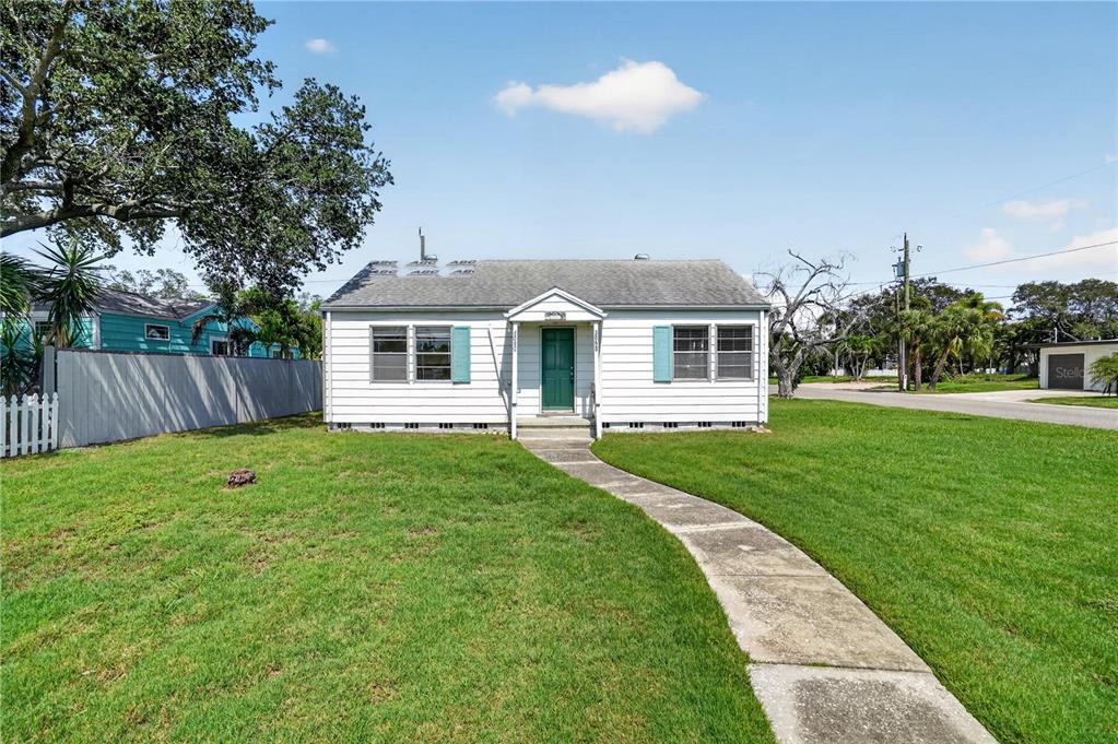 A white, single-story house with a green front door and a concrete walkway — 3050 DUPONT STREET S, GULFPORT, FL