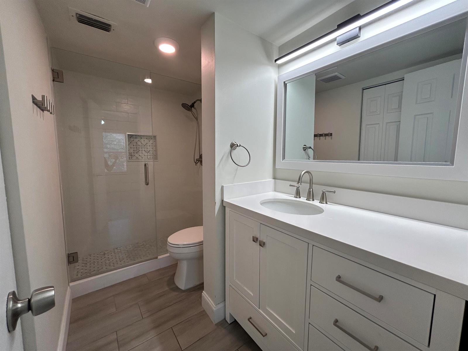 A bathroom features a glass-enclosed shower, a white vanity with a sink, and tile flooring — 21906 Lake Forest Circle, Boca Raton FL 33433, BOCA RATON, FL