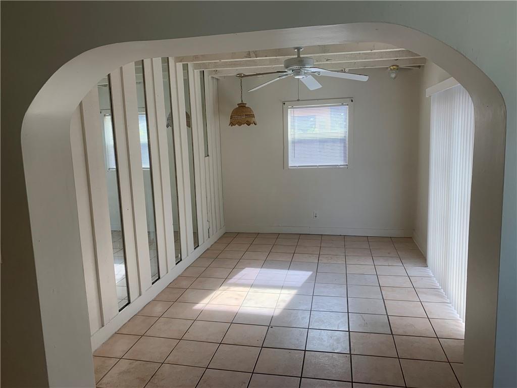 A dining room with tiled floors, a ceiling fan, and a mirrored wall feature — 6410 Coolidge Street, Hollywood FL 33024, HOLLYWOOD, FL