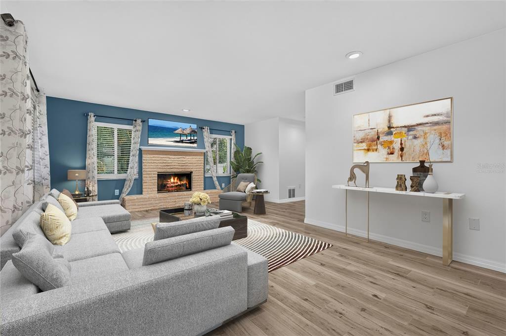 A living room features a gray sectional sofa, a brick fireplace, and a console table — 2129 LINWOOD DRIVE, SARASOTA, FL