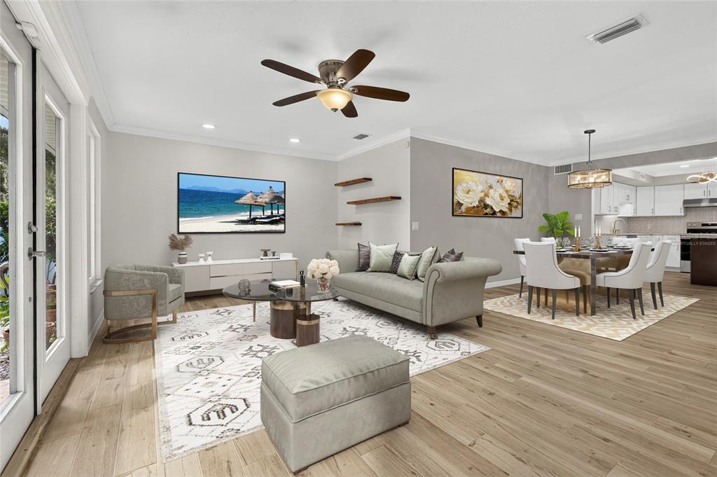 This virtually staged living and dining area features light wood floors and a ceiling fan — 2129 LINWOOD DRIVE, SARASOTA, FL