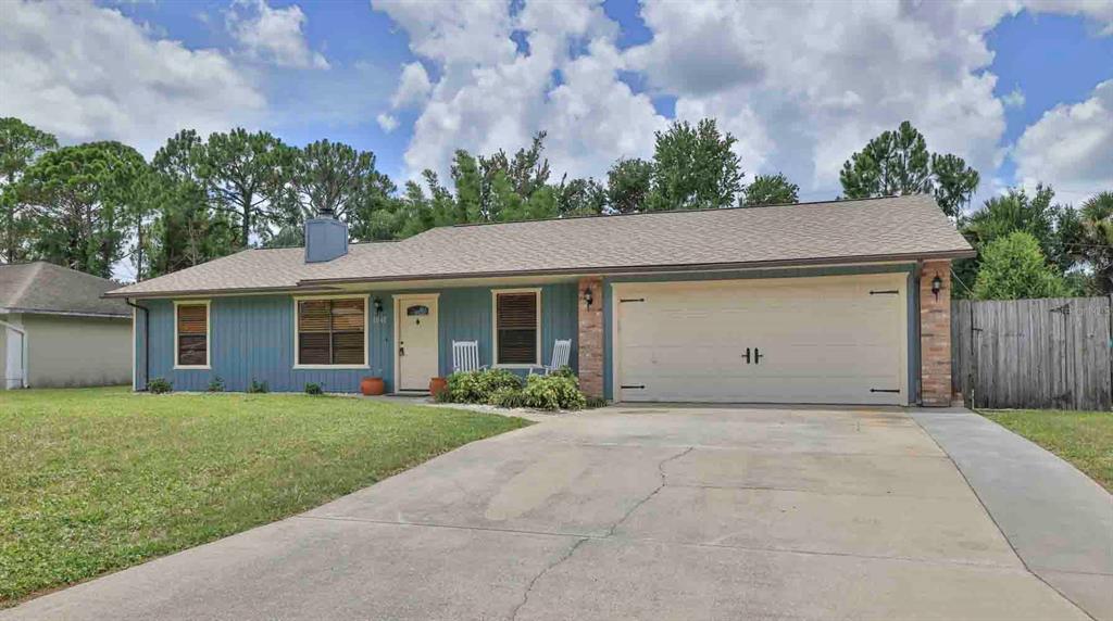 A single-story house with blue siding, a two-car garage, and a concrete driveway — 1618 WILLOW OAK DRIVE, EDGEWATER, FL