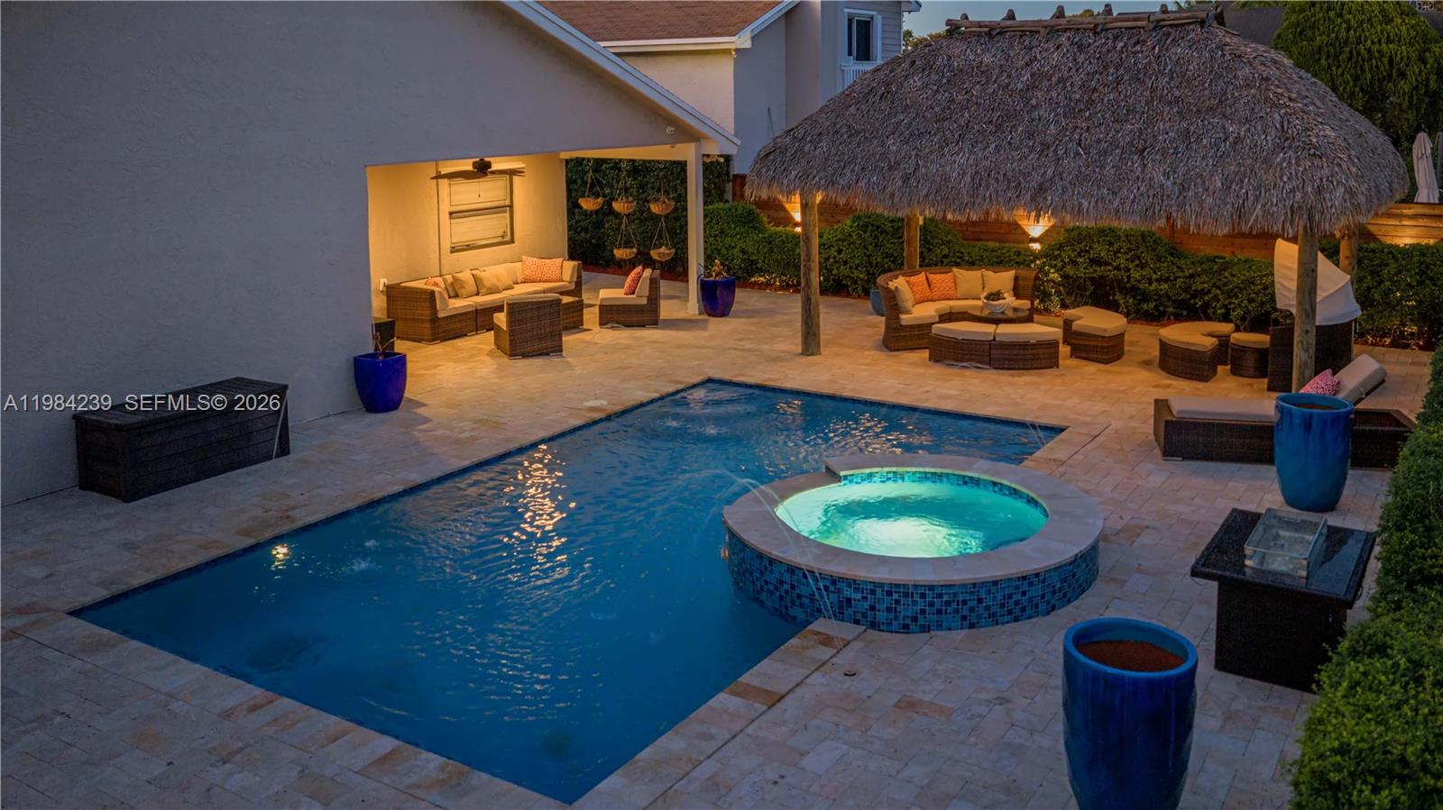 A backyard features a swimming pool, a hot tub, a tiki hut, and patio furniture — 5321 SW 153rd Pl S, Miami FL 33185, MIAMI, FL