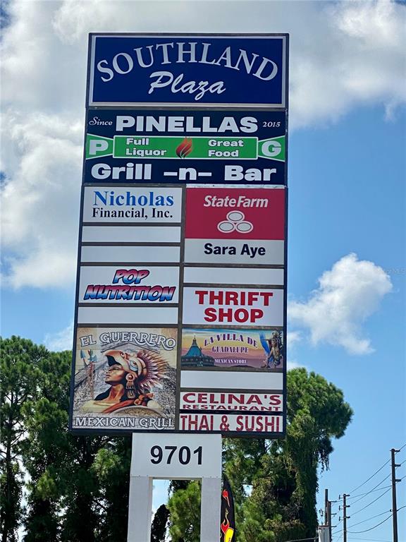 A tall, multi-tenant commercial plaza sign stands against a blue sky with clouds — 9701 N 66TH STREET, PINELLAS PARK, FL
