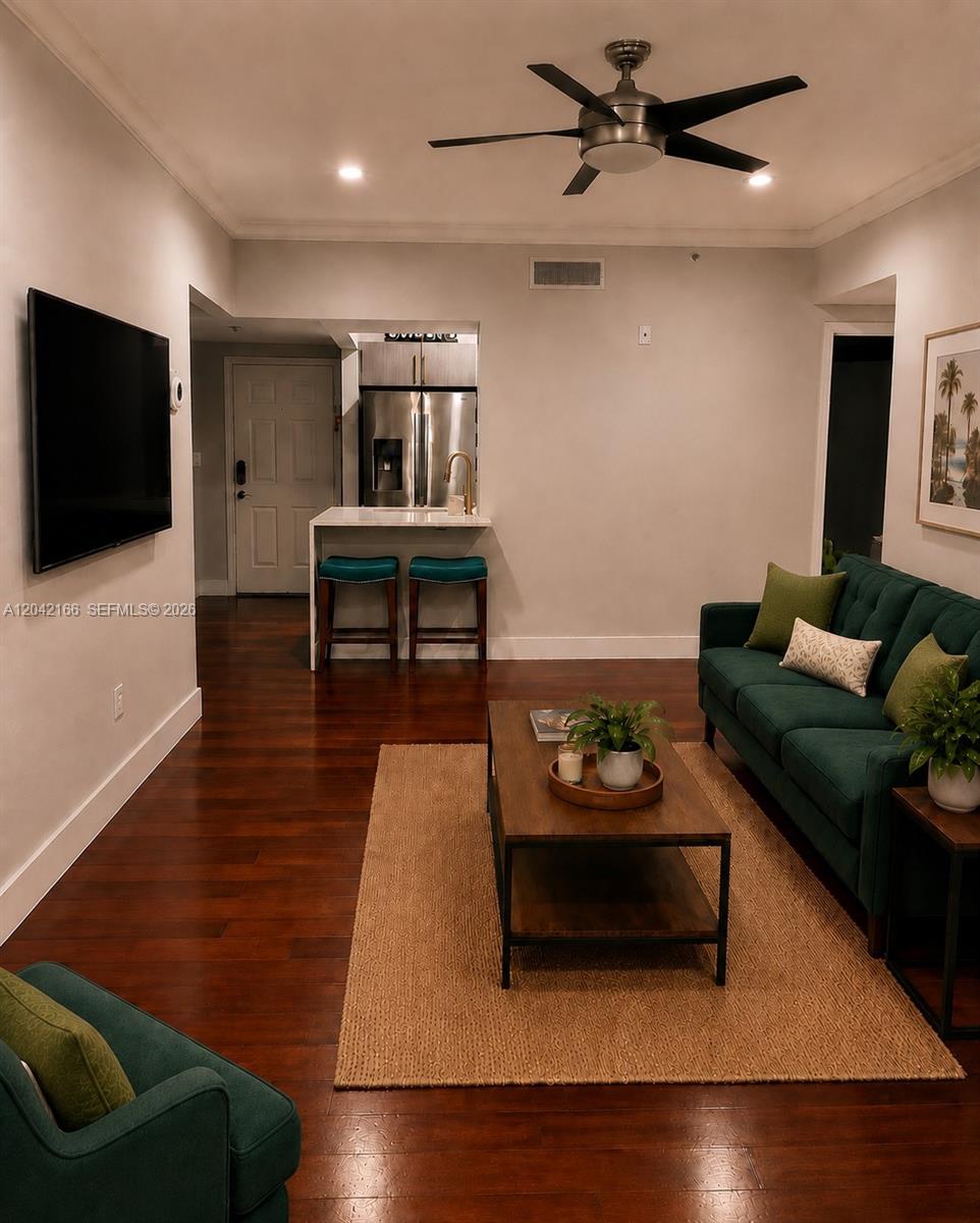 A living room features a green sofa, a coffee table, and a small kitchen area — PEMBROKE PINES, FL