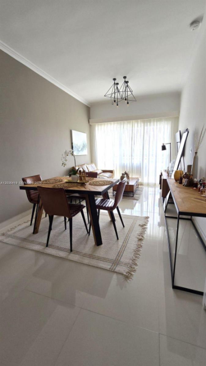 A dining area with a wooden table and chairs sits on a rug in a room — 0 Cocotal # 0, FL, FL