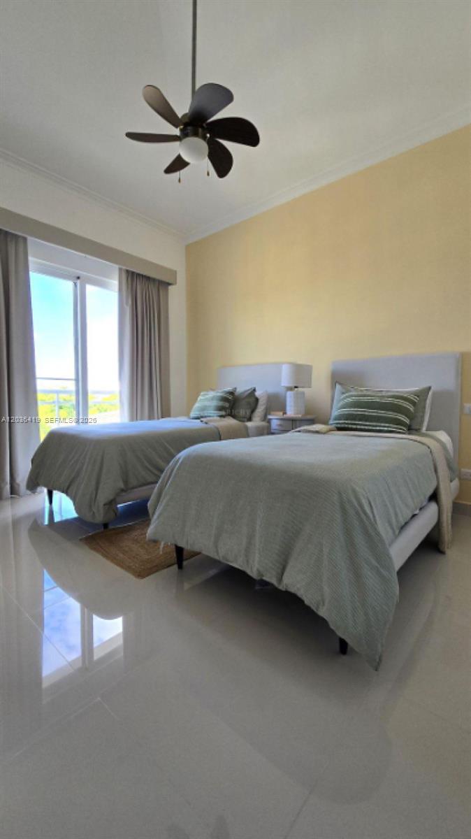 A bedroom features two twin beds, a ceiling fan, and a large window with curtains — 0 Cocotal # 0, FL, FL