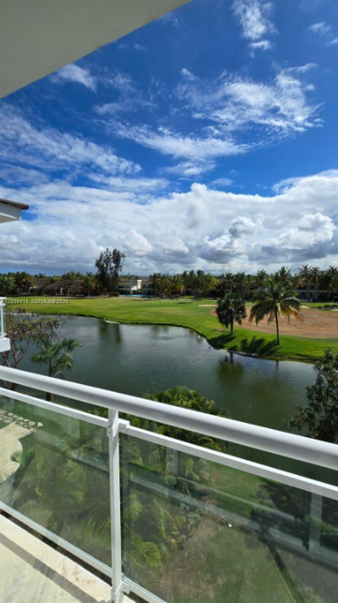 A balcony overlooks a pond, a golf course, and palm trees under a cloudy sky — 0 Cocotal # 0, FL, FL