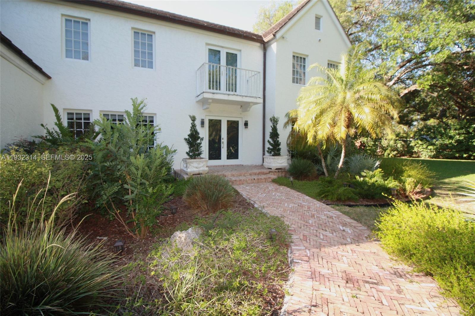 A two-story white house features a brick walkway leading to a double-door entrance — 6750 Granada Blvd, Coral Gables FL 33146, CORAL GABLES, FL