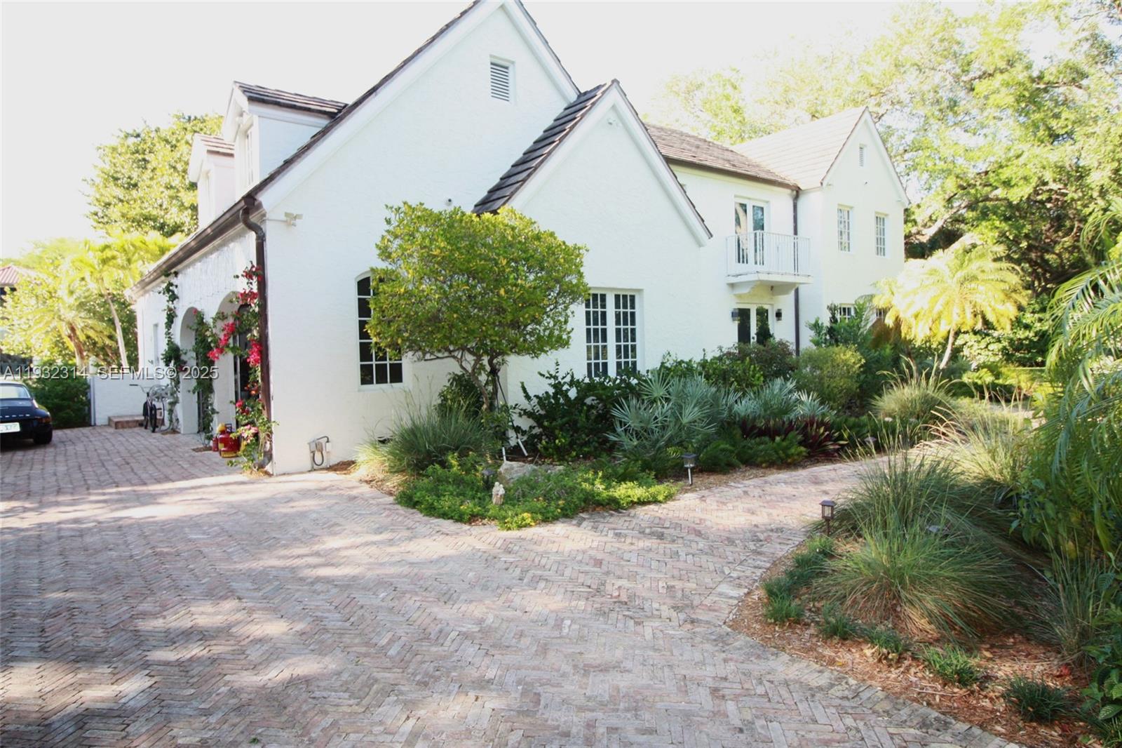 A white two-story house with a brick driveway and lush landscaping — 6750 Granada Blvd, Coral Gables FL 33146, CORAL GABLES, FL