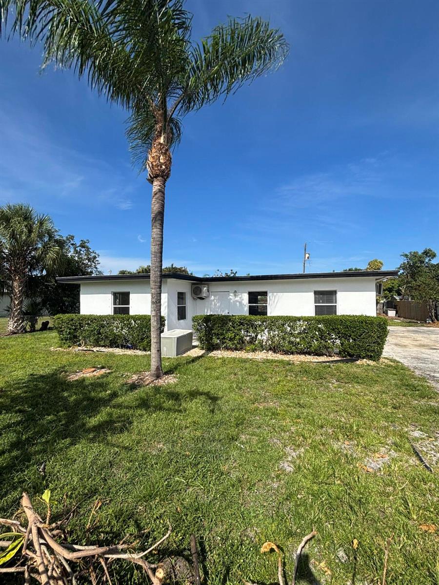 A white, single-story house with a palm tree in the front yard — 328 Urquhart Street, FL 33461, FL