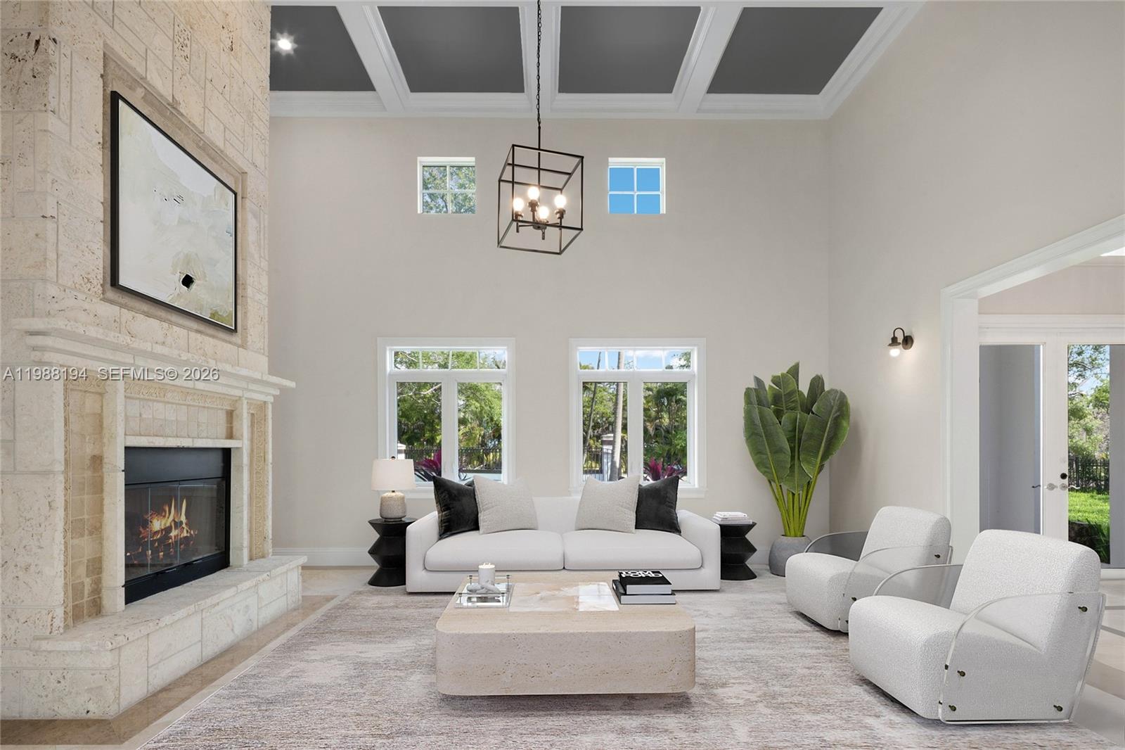 A high-ceilinged living room features a stone fireplace, white sofa, and two modern armchairs — 6200 SW 130th Ter, Pinecrest FL 33156, PINECREST, FL