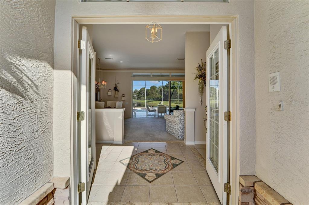 An entryway with a tiled floor and decorative inlay leads into a living area — 740 SALT LAKE DRIVE, TARPON SPRINGS, FL
