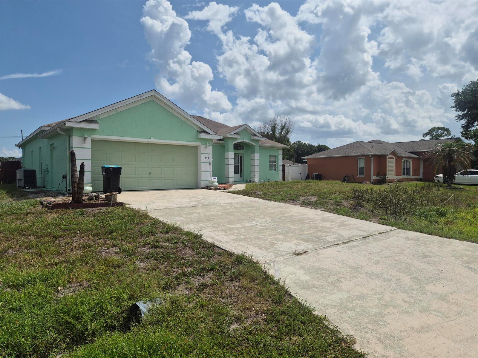 The exterior of a mint green house with a screened-in porch and a grassy yard — 698 Thuringer Street NW, Palm Bay FL 32907, PALM BAY, FL