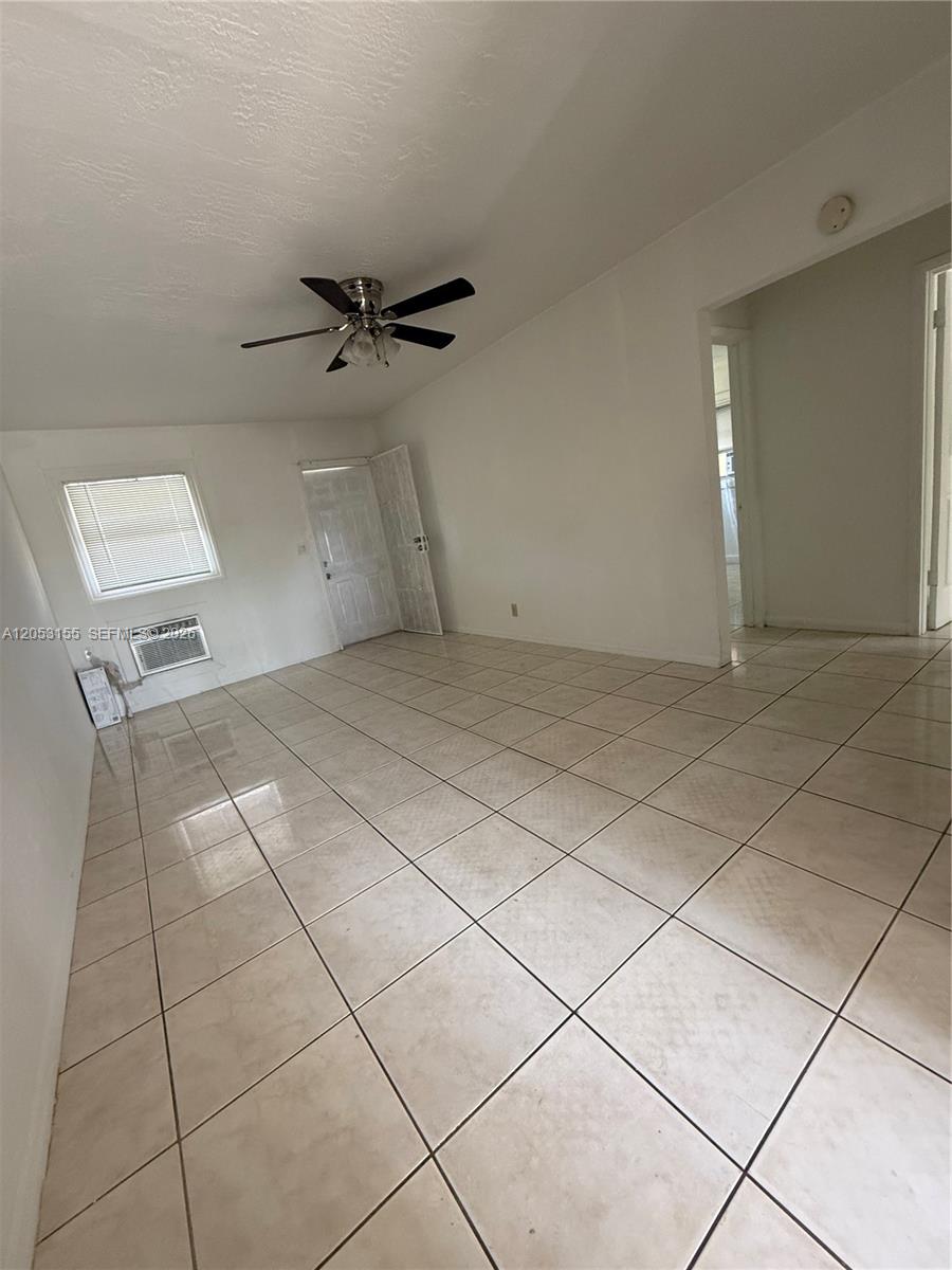 A sparsely furnished room features white walls, a ceiling fan, and light-colored tiled flooring — 708 N 20th Ct # 2, Hollywood FL 33020, HOLLYWOOD, FL