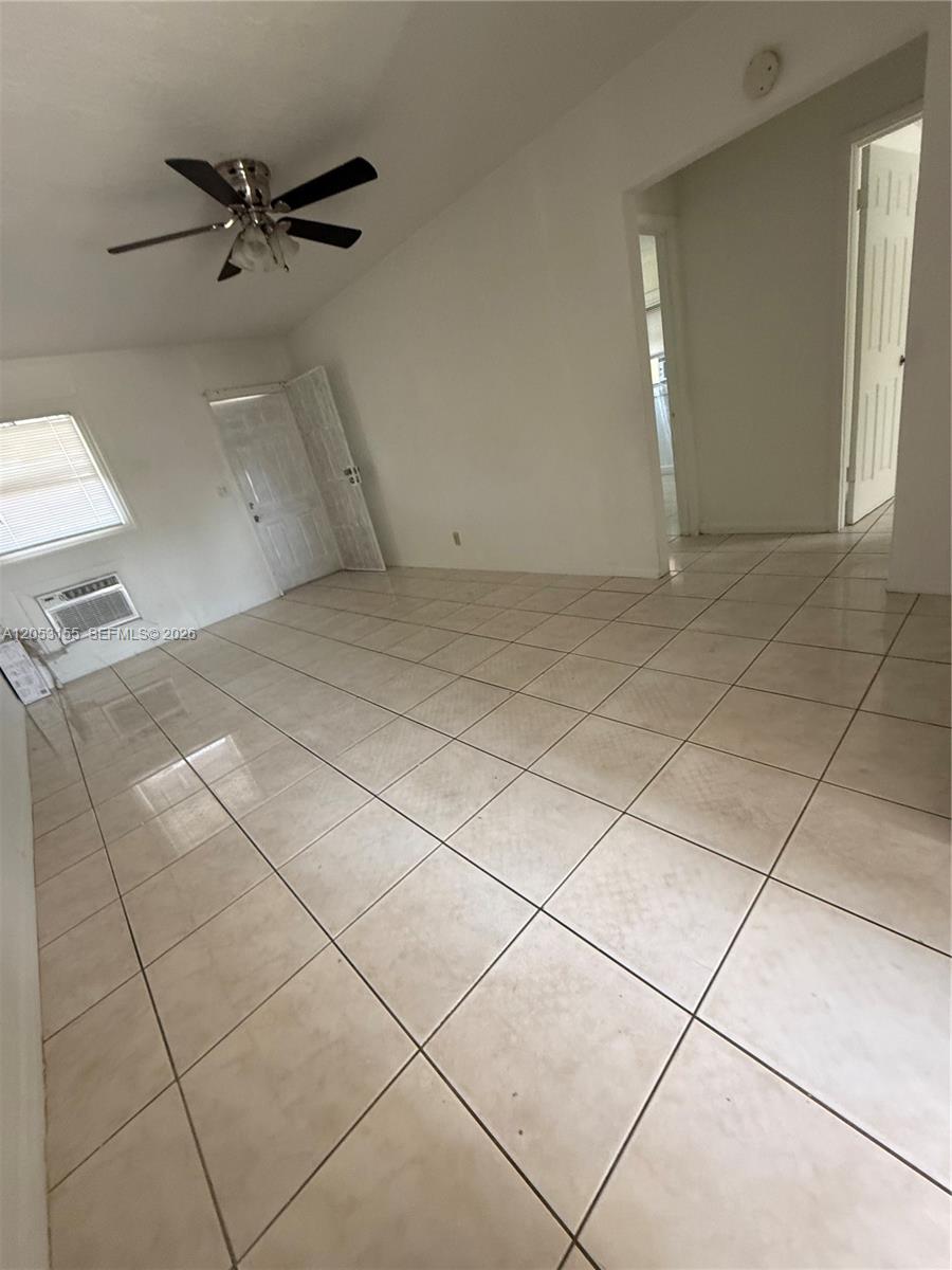 An empty room features white walls, a vaulted ceiling with a fan, and tiled flooring — 708 N 20th Ct # 2, Hollywood FL 33020, HOLLYWOOD, FL