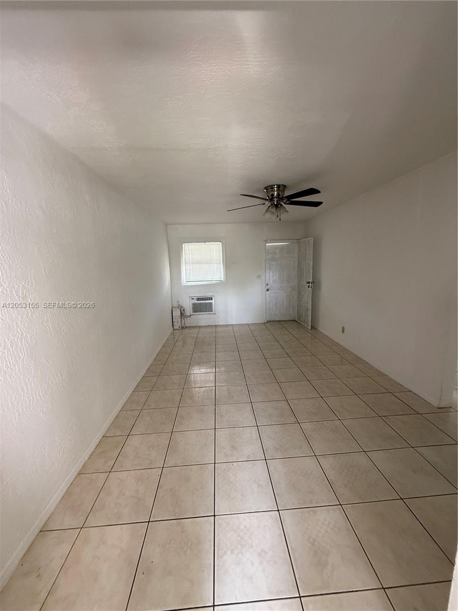 A sparsely furnished room features white walls, a tiled floor, and a ceiling fan — 708 N 20th Ct # 2, Hollywood FL 33020, HOLLYWOOD, FL