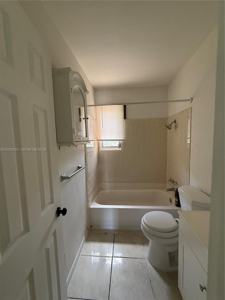 A small bathroom features a white tub, toilet, vanity, and wall-mounted cabinet — 708 N 20th Ct # 2, Hollywood FL 33020, HOLLYWOOD, FL