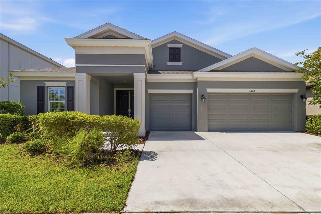 A single-story gray house features a three-car garage and a covered front entryway — 6404 MAIDEN SEA DRIVE, APOLLO BEACH, FL