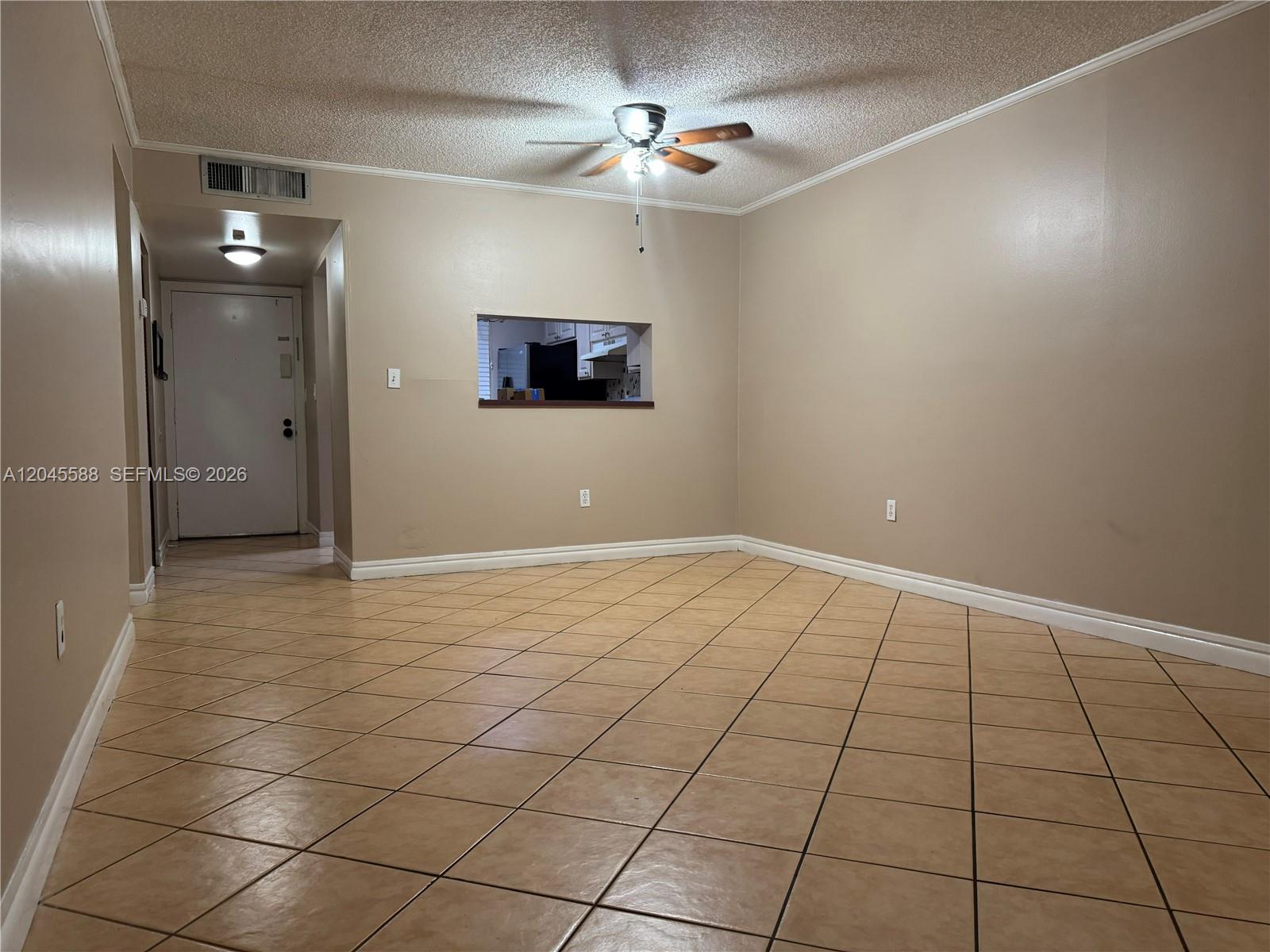 An empty room features tan walls, a popcorn ceiling, a ceiling fan, and tiled floors — 10865 SW 112th Ave # 105, Miami FL 33176, MIAMI, FL