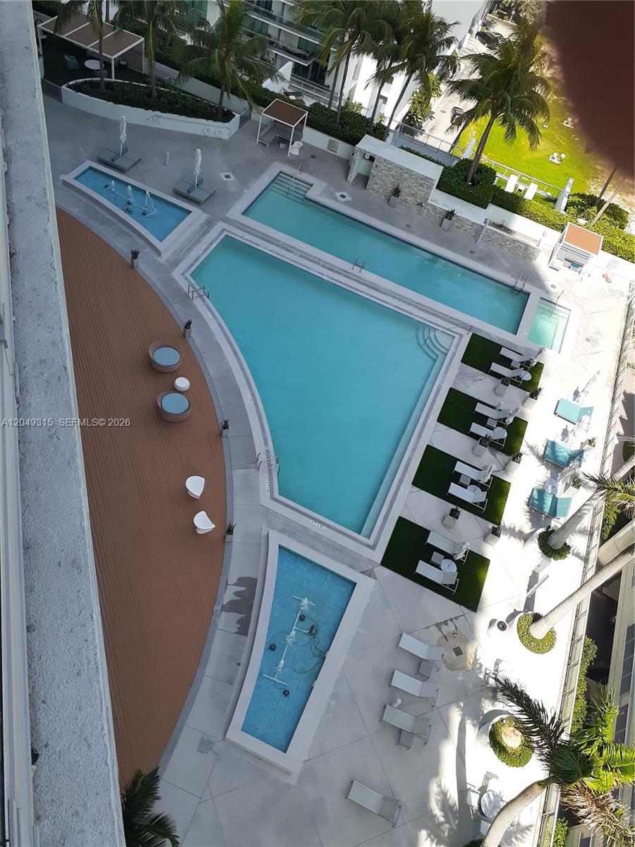 An aerial view shows a multi-section swimming pool with lounge chairs on a paved deck — 90 SW 3rd St # 1914, Miami FL 33130, MIAMI, FL