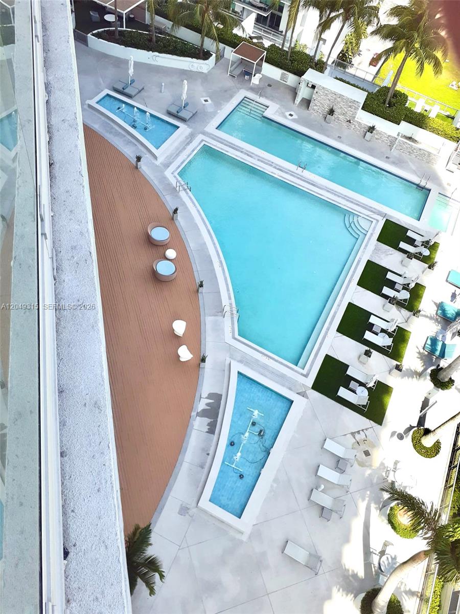 An aerial view shows a swimming pool complex with lounge chairs and a wooden deck — 90 SW 3rd St # 1914, Miami FL 33130, MIAMI, FL