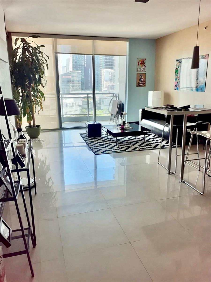 A modern living room with tile floors, a balcony, and a dining area — 90 SW 3rd St # 1914, Miami FL 33130, MIAMI, FL