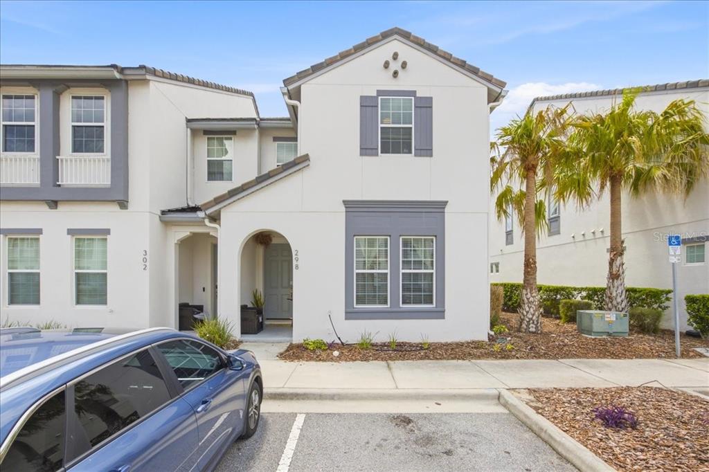 A two-story townhouse with white stucco walls, gray trim, and a covered front entryway — 298 CAPTIVA DRIVE, DAVENPORT, FL