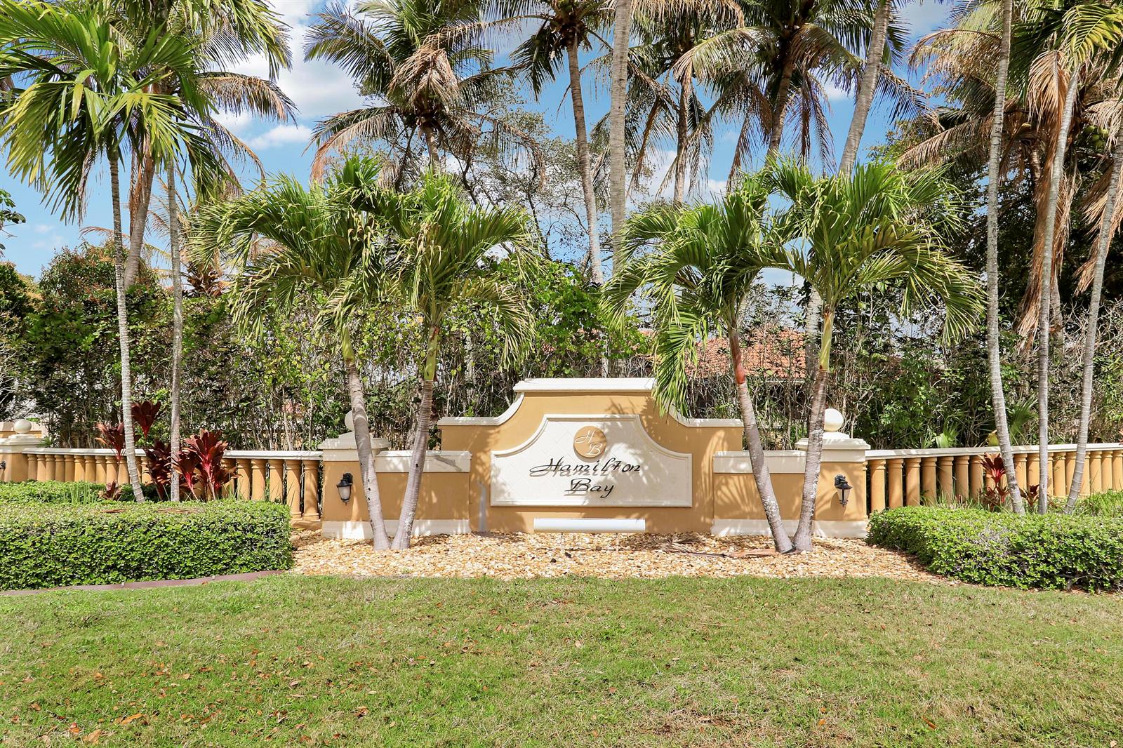 A beige stucco monument sign for Hamilton Bay stands surrounded by palm trees and landscaping — 4008 W Hamilton Key, West Palm Beach FL 33411, WEST PALM BEACH, FL