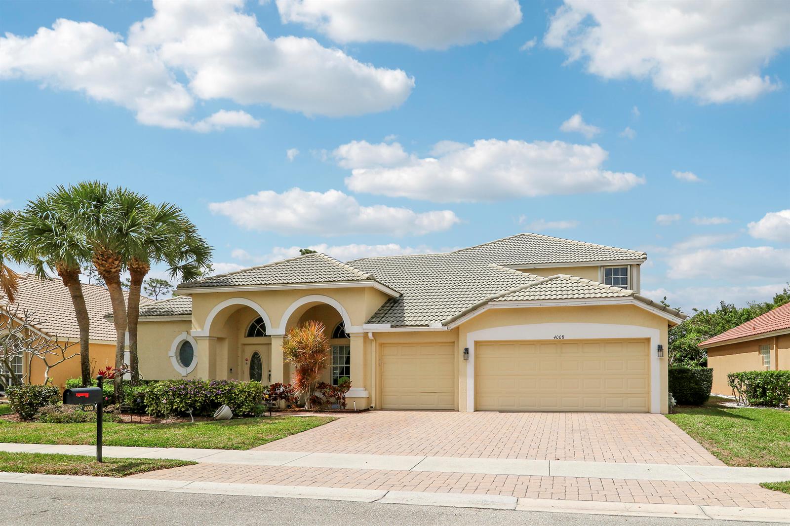 A single-story yellow stucco house with a tiled roof and a three-car garage — 4008 W Hamilton Key, West Palm Beach FL 33411, WEST PALM BEACH, FL