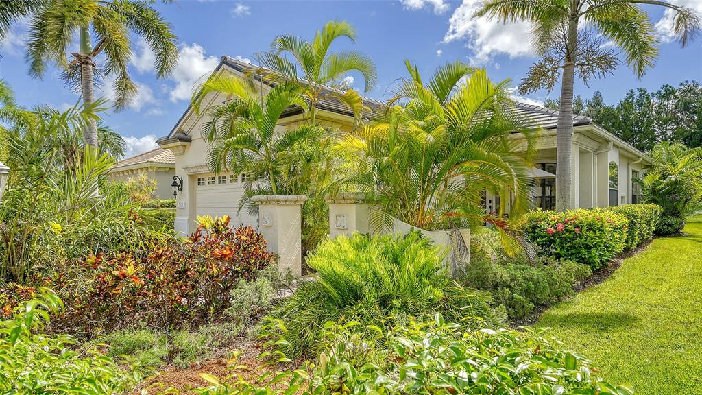 A single-story house with a garage and lush tropical landscaping under a blue sky — 7223 PRESIDIO GLEN, LAKEWOOD RANCH, FL