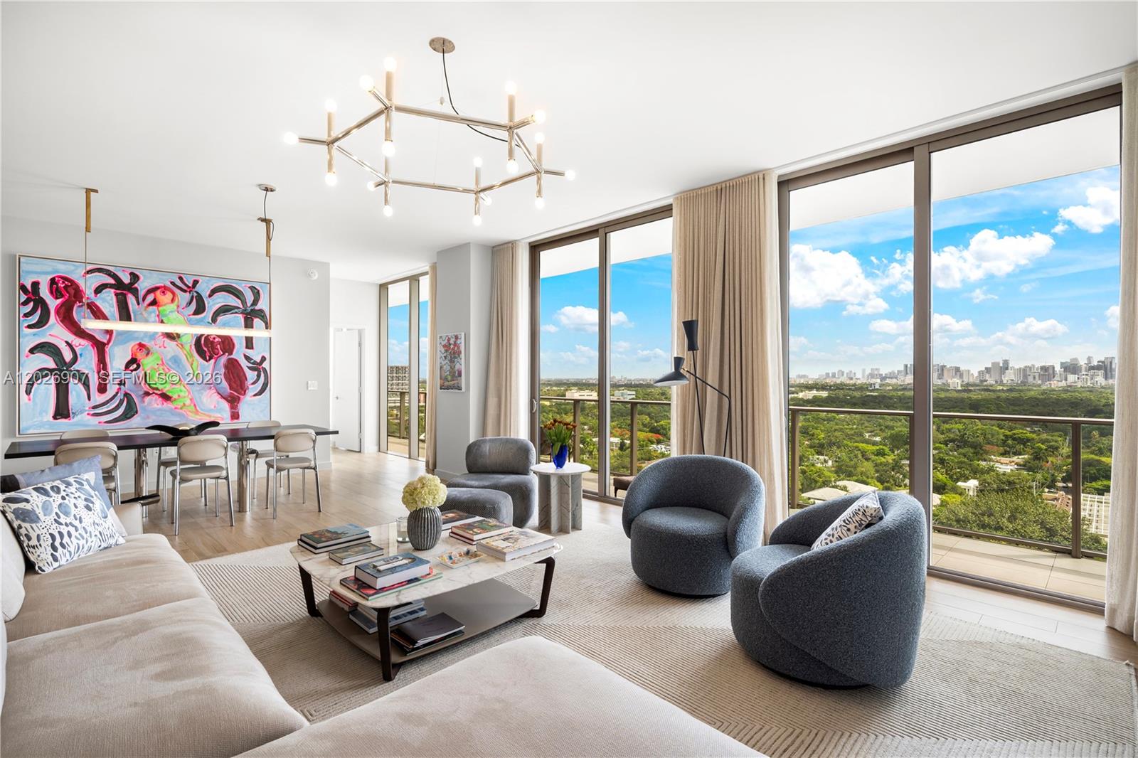A modern living and dining room features floor-to-ceiling windows with a city and park view — 2678 Tigertail Ave # 1702, Miami FL 33133, MIAMI, FL